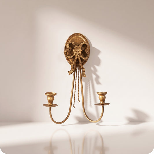 Candelabro dorado con moño y dos porta velas