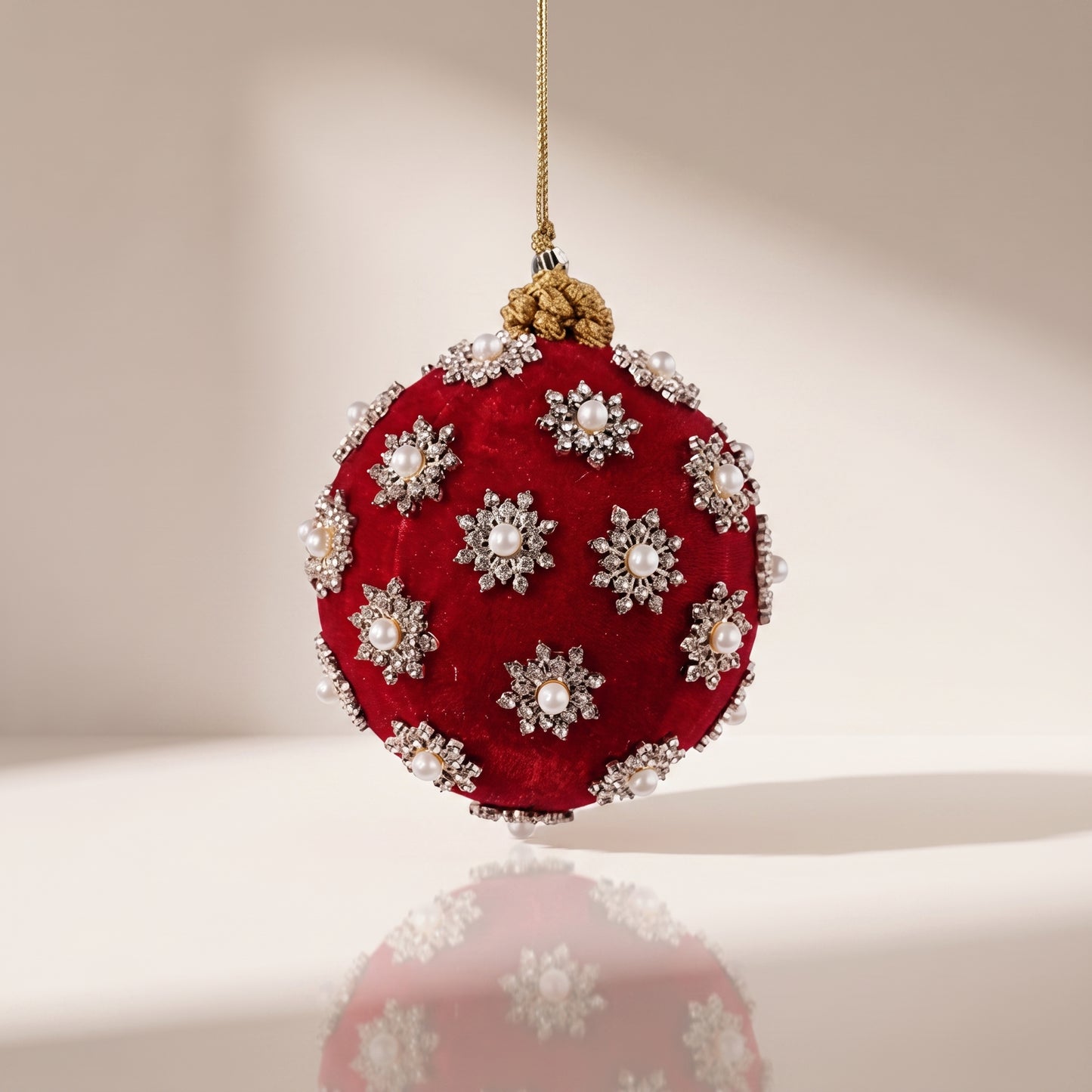 Esfera de terciopelo rojo con perlas blancas al rededor